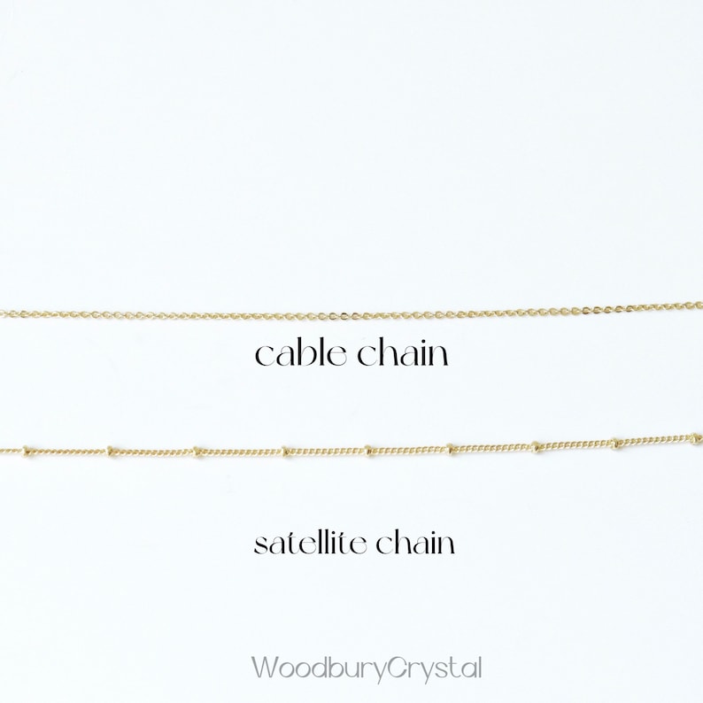 May include: Two gold chains on a white background. The top chain is a cable chain and the bottom chain is a satellite chain. The text "WoodburyCrystal" is at the bottom of the image.