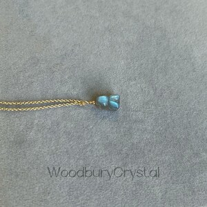 May include: A gold chain necklace with a blue labradorite pendant. The pendant is a raw, irregular shape.