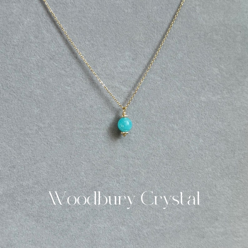 May include: A delicate gold chain necklace with a single turquoise gemstone pendant.