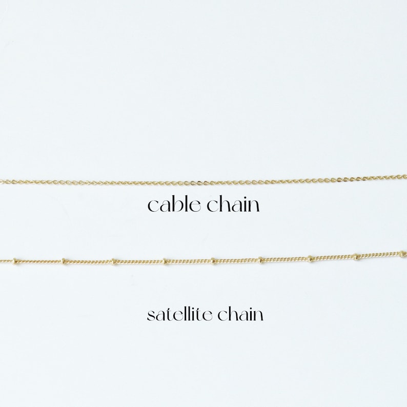 May include: Two gold chains on a white background. The top chain is a cable chain. The bottom chain is a satellite chain.