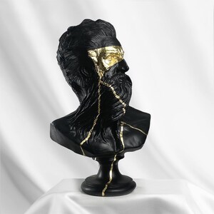 Puede incluir: Busto de escultura de un hombre con barba en negro y dorado. La escultura est&aacute; agrietada y tiene detalles dorados.