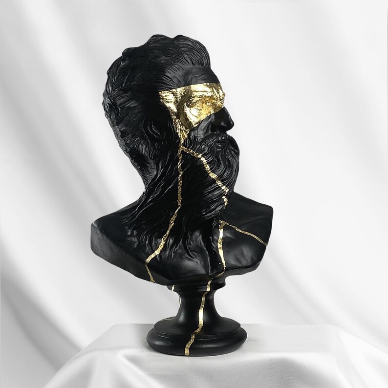 Puede incluir: Busto de escultura de un hombre con barba en negro y dorado. La escultura est&aacute; agrietada y tiene detalles dorados.