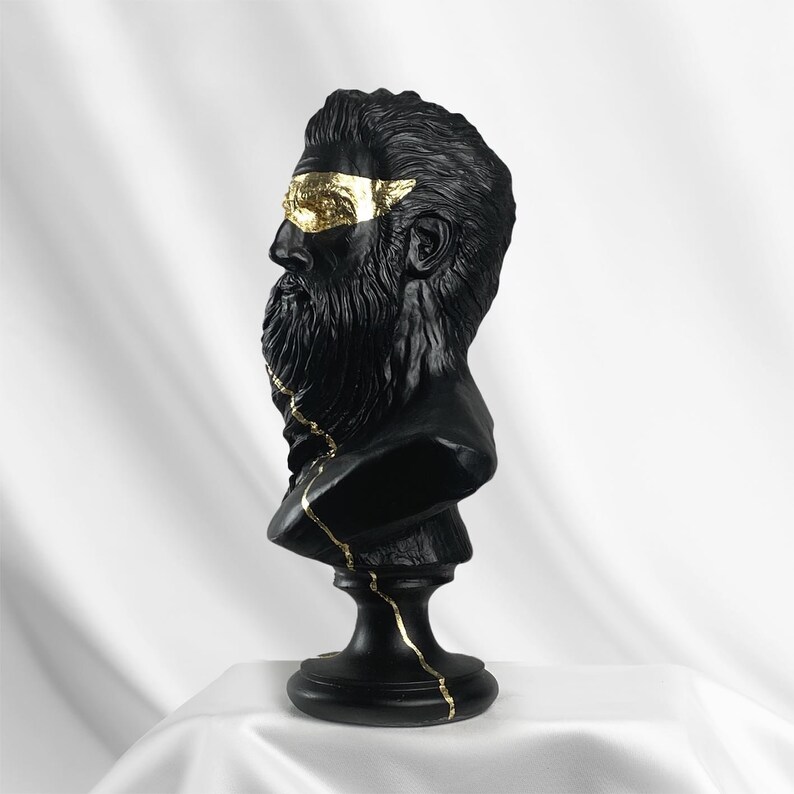 Puede incluir: Busto de escultura de un hombre con barba en negro y dorado. El busto est&aacute; agrietado y tiene detalles dorados.