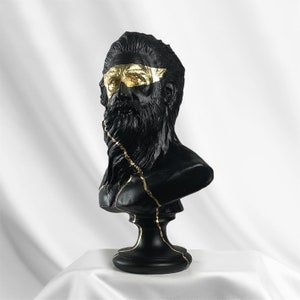 Puede incluir: Busto de escultura de un hombre con barba en negro y dorado. El busto est&aacute; agrietado y tiene detalles dorados.