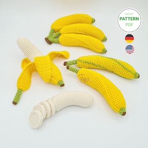 Peut inclure: Plusieurs bananes crochetées à la main, entières, pelées et coupées. Les bananes sont principalement jaunes avec des détails verts et marron, et une peau de banane crème. L'image comprend un graphique "CROCHET PATTERN PDF".