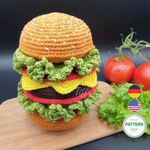 Puede incluir: Patrón de crochet para un juguete amigurumi de hamburguesa. El patrón incluye instrucciones para hacer el pan, la lechuga, el queso, el tomate y la carne. El patrón está disponible en formato PDF.