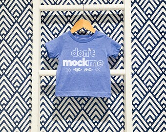 Op de afbeelding: Een blauw T-shirt met de tekst "don't mock me use me" in wit gedrukt op de voorkant.