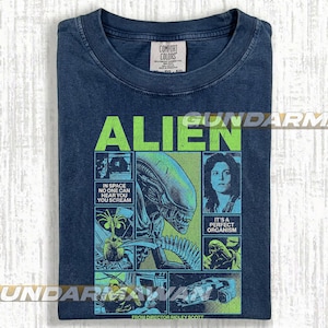 Pode incluir: Camiseta azul marinho com um gr&aacute;fico do filme "Alien". O design inclui a palavra "ALIEN" em verde, imagens do alien&iacute;gena e o texto "IN SPACE NO ONE CAN HEAR YOU SCREAM". O nome do diretor tamb&eacute;m &eacute; vis&iacute;vel.