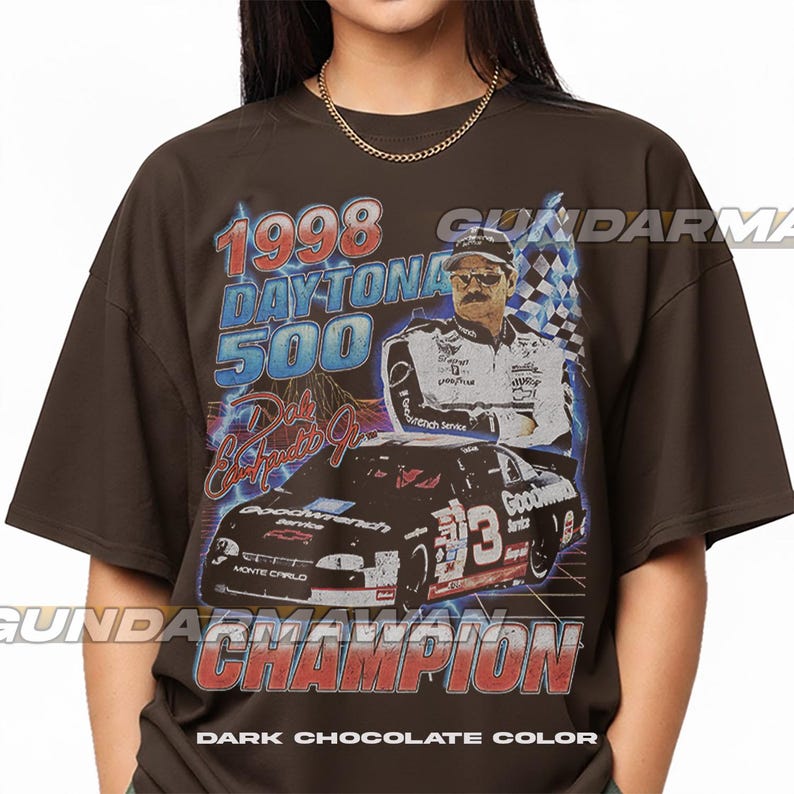 Peut inclure: Un t-shirt marron chocolat fonc&eacute; avec une impression graphique du Daytona 500 de 1998, Dale Earnhardt Jr. et sa voiture de course num&eacute;ro 3. Le design inclut le texte 1998 DAYTONA 500, Dale Earnhardt Jr. et CHAMPION dans un style vintage us&eacute;.