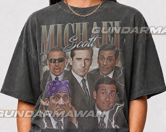 Könnte beinhalten: Ein anthrazitfarbenes Kurzarm-T-Shirt mit einem Grafikdruck von Michael Scott in verschiedenen Ausdrücken. Das Design enthält den Text "MICHAEL" in großen Buchstaben und "Scott" in Schreibschrift, mit Blitzmotiven, die die Porträts umgeben.