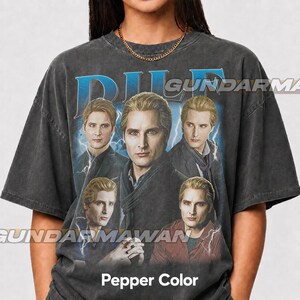 May include: A charcoal gray short-sleeve t-shirt featuring a graphic print of a man with blonde hair in five different poses. The text DILF is printed in large blue letters at the top. The shirt has a crew neckline and a relaxed, boxy fit.