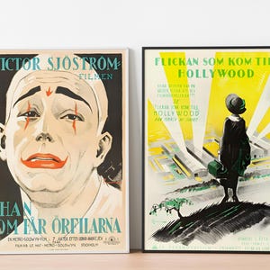May include: Two vintage movie posters in black frames. The poster on the left features a black and white image of a man with clown makeup and the text "VICTOR SJ&Ouml;STROM FILMEN HAN SOM F&Aring;R ORFILARNA". The poster on the right features a yellow background with a black and white image of a woman in a dress and the text "FLICKAN SOM KOM TILL HOLLYWOOD".