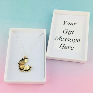 May include: A silver chain necklace with a gold pencil shaving pendant in a white gift box. The box has a white card inside with the text "Your Gift Message Here".