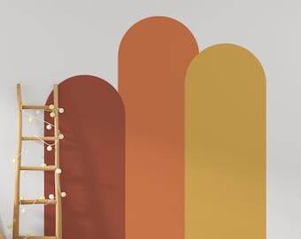 Puede incluir: Tres formas arqueadas pintadas en una pared blanca. Las formas son en tonos de naranja, amarillo y marrón.