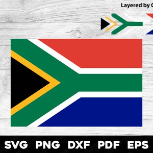 Puede incluir: Una bandera de Sudáfrica con los colores rojo, amarillo, verde, negro y azul. La bandera está sobre un fondo de madera blanca.