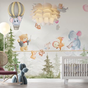 May include: A whimsical nursery scene featuring a white crib, a rocking chair, and a blue balloon dog. The wall is adorned with watercolor illustrations of animals, hot air balloons, and trees, creating a playful and inviting atmosphere.
