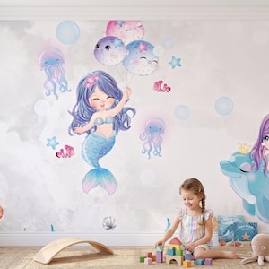 May include: A wall mural featuring two mermaids with purple hair, one holding balloons, surrounded by sea creatures including a turtle, jellyfish, and a dolphin. The design includes soft blue, purple, and pink tones on a light grey background.