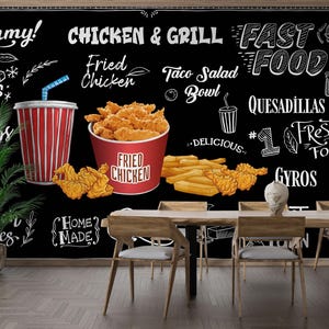 Peut inclure: Une murale murale noire de style tableau noir avec des illustrations de restauration rapide. La murale comprend du texte tel que "Yummy!", "Chicken & Grill", "Fast Food", et des éléments de menu comme du poulet frit et des quesadillas. Une tasse à rayures rouges et blanches avec une paille est également visible.
