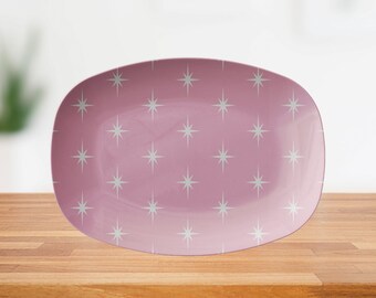 May include: A pink oval serving platter with a white starburst pattern.