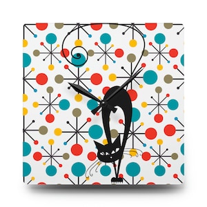 Könnte beinhalten: Eine schwarze Katzensilhouette-Uhr mit weißem Hintergrund und einem Retro-Muster aus roten, gelben, blauen und braunen Kreisen und Sternen.