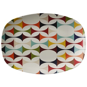 May include: A white oval serving platter with a colorful geometric pattern. The pattern features overlapping circles and triangles in shades of red, orange, yellow, green, blue, and black.