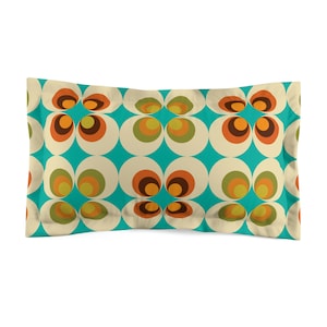 Puede incluir: Una almohada turquesa con un patrón retro de círculos superpuestos en tonos naranja, marrón, amarillo y verde.