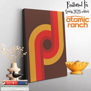 May include: Abstract geometric art print with a brown background and overlapping circles in shades of red, orange, and yellow. The print is titled "Featured In Spring 2025 edition atomic ranch".
