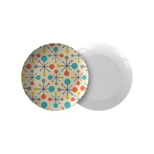 May include: A set of two ceramic plates, one with a white background and the other with a retro-style pattern of colourful circles and stars.