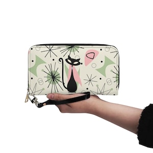 May include: A black and white zippered wallet with a retro design featuring a black cat and pink and green geometric shapes.