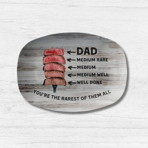 May include: A wooden oval serving platter with a graphic of a steak and a scale showing different levels of doneness. The text reads "Dad You're the rarest of them all".