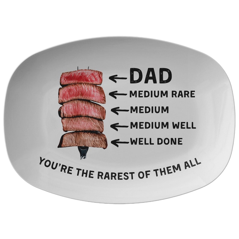 May include: White ceramic serving platter with a graphic of a stack of steaks and arrows pointing to different levels of doneness. The text reads "DAD" and "YOU'RE THE RAREST OF THEM ALL".