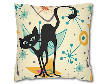 May include: A black cat silhouette on a cream colored pillow with a mid-century modern design. The design features yellow, blue, and orange abstract shapes and stars.