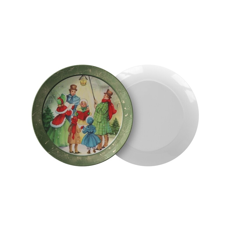 May include: A green ceramic plate with a vintage Christmas scene of carolers singing in the snow. The plate has a gold rim and a white background.