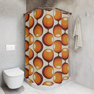 May include: A shower curtain with a retro pattern of orange, brown, and white circles. The curtain is hanging in a bathroom with a white toilet and tiled walls.