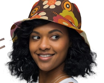 May include: A woman wearing a brown bucket hat with a colorful floral pattern. The hat has a wide brim and is made of a soft, comfortable material.