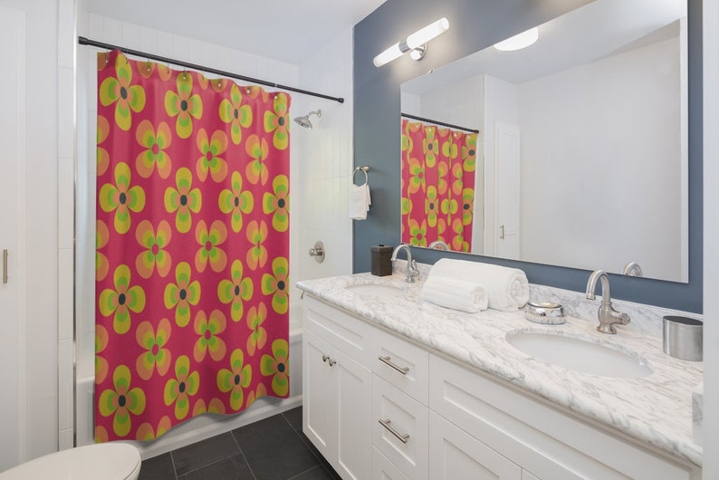 May include: A bathroom with a white vanity and a shower curtain with a retro floral pattern in shades of pink, yellow, and green.