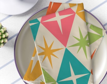 May include: A set of two fabric napkins with a geometric pattern of colorful stars and diamonds on a cream background.