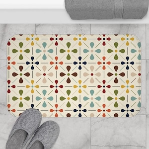 Puede incluir: Una alfombra de baño beige con un patrón geométrico de flores rojas, azules, verdes, marrones y amarillas. El patrón se repite en toda la alfombra.