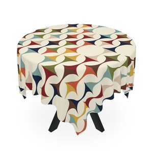 May include: A round tablecloth with a geometric pattern in shades of red, orange, yellow, green, blue, and brown. The tablecloth is cream-colored with a repeating pattern of stylized stars.