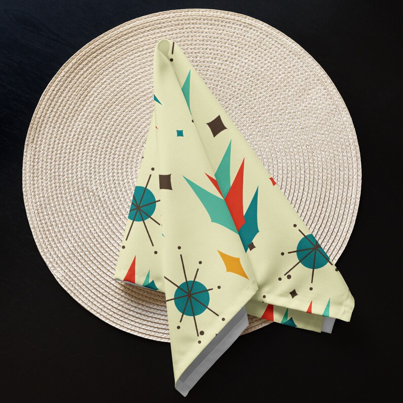 May include: A yellow, white, blue, red, and orange geometric patterned cloth napkin with a mid-century modern design.