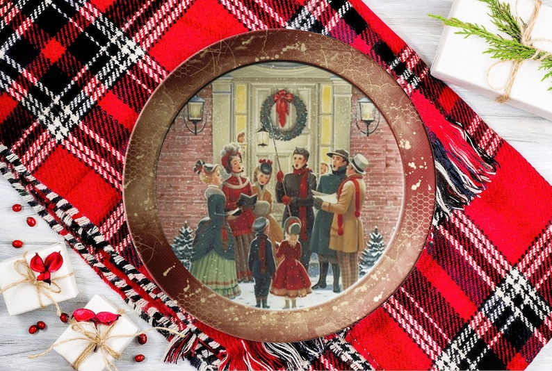 May include: A vintage-style Christmas plate featuring a group of carolers singing in front of a house decorated with a wreath. The plate has a brown background with a distressed finish.