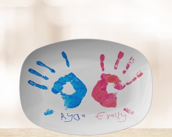 May include: White oval ceramic serving platter with two handprints, one blue and one pink, and the names "Ryan" and "Emily" written underneath.
