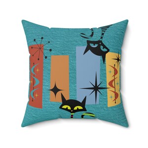 Può includere: Un cuscino blu turchese con un design moderno di metà secolo che presenta gatti neri, forme geometriche arancioni, blu e rosse e stelle bianche.