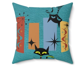 May include: A turquoise blue throw pillow with a mid-century modern design featuring black cats, orange, blue, and red geometric shapes, and white stars.
