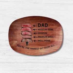 May include: A wooden serving tray with a steak graphic and the text "DAD You're the rarest of them all". The steak graphic shows different levels of doneness, with arrows pointing to the corresponding text: "DAD", "Medium Rare", "Medium", "Medium Well", and "Well Done".