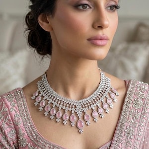 May include: A white ceramic mug with a black handle and the text "But First, Coffee" in a bold, black font. The mug is set against a blurred background, suggesting a cozy setting.