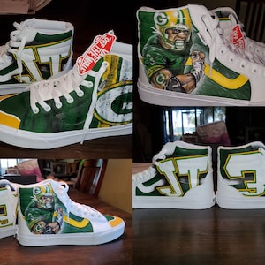 May include: Custom-painted high-top sneakers in white, green, and yellow, featuring a football theme. One pair showcases a player portrait, while the other displays the team's logo and initials. The shoes have white laces and soles.