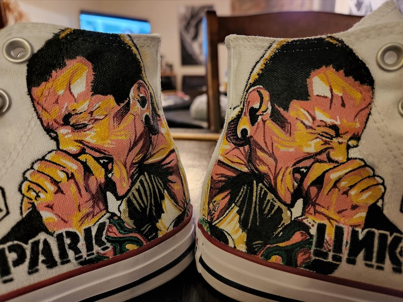 May include: A white ceramic mug with a black handle and the text "But First, Coffee" in a handwritten style. The mug is on a white surface. The mug is approximately 4 inches tall.