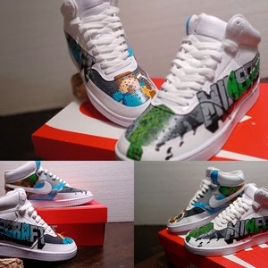May include: White high-top sneakers with custom Minecraft-themed artwork. The shoes feature hand-painted designs with the Minecraft logo and characters in various colors. The sneakers are displayed on a red Nike box.