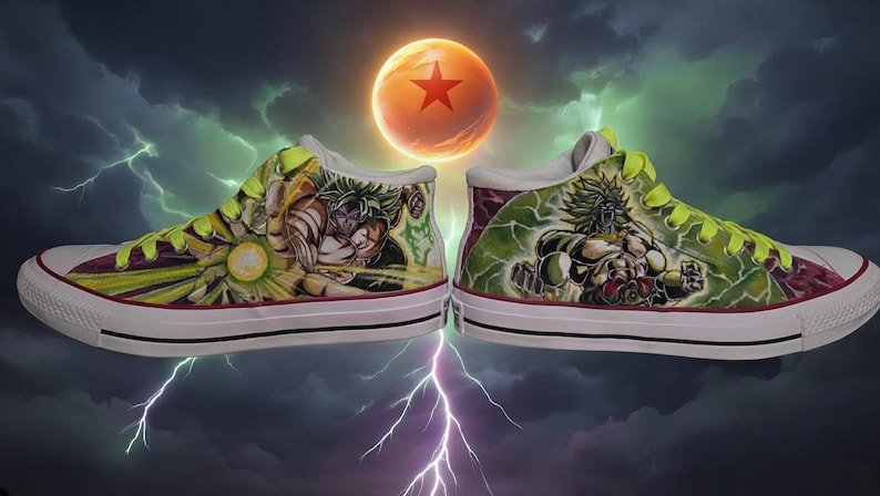 May include: Pair of custom high-top sneakers featuring detailed artwork of a character from Dragon Ball Z. The shoes have a white rubber sole, with the artwork in shades of green, yellow, and brown. The background shows a stormy sky and a glowing orange orb.